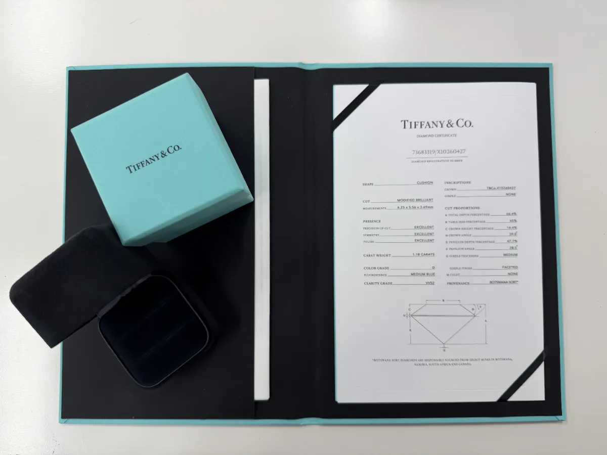 Tiffany & Co. Diamond Certificate in its folder next to a Tiffany Blue Box and ring box